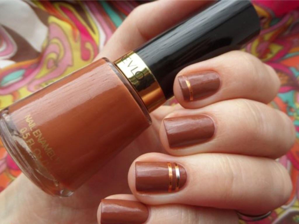 nail polish bottle and nails painted light brown