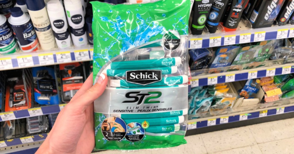 hand holding Schick Xtreme 2 Sensitive Disposable Razors with shaving items behind it at walgreens