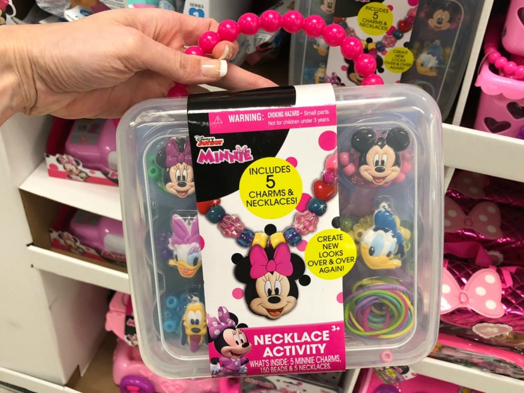 hand holding up Disney minnie mouse toy that has necklace building beads in it