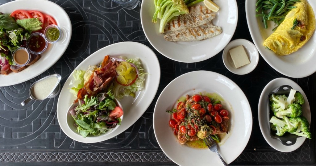 plates of different The Cheesecake Factory meals on table