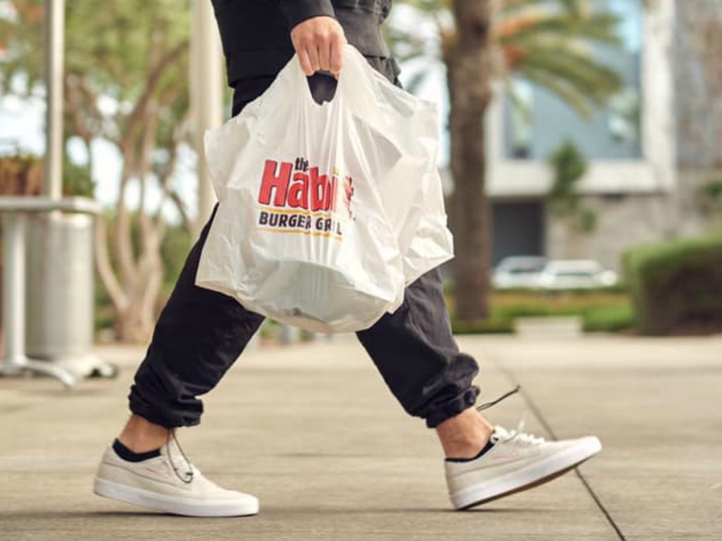 Person carrying The Habit Burger Takeout Bags