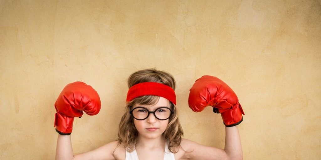 Child wearing boxing gloves and sweat band looking fierce