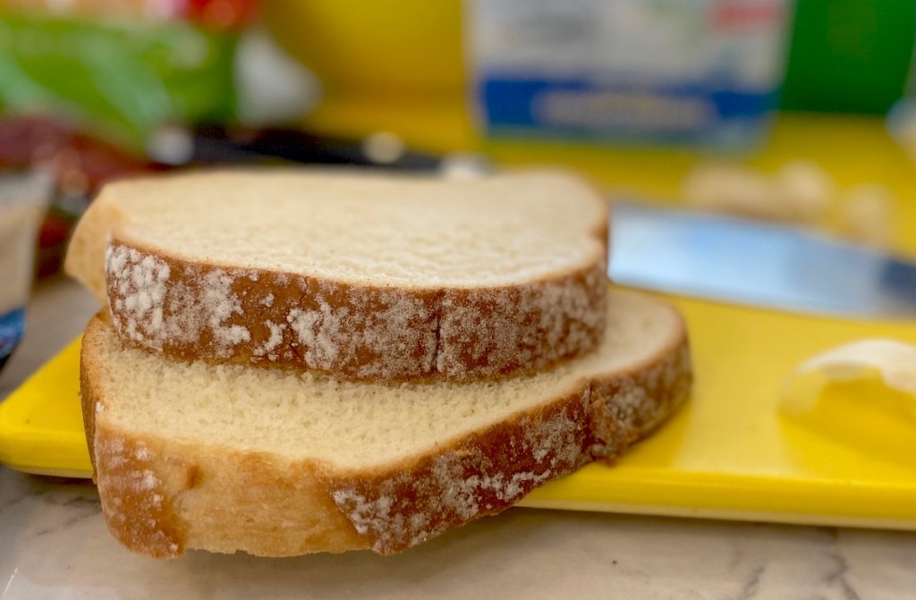 two slices of bread sitting on yellow cutting board