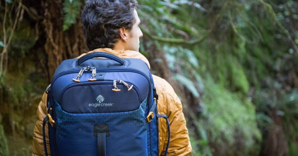 man wearing yellow coat and blue backpack