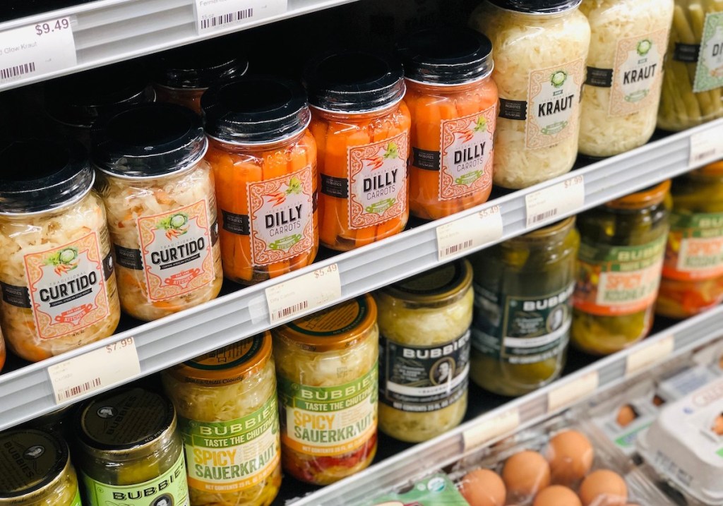 fermented foods in jars of refrigerated section at store