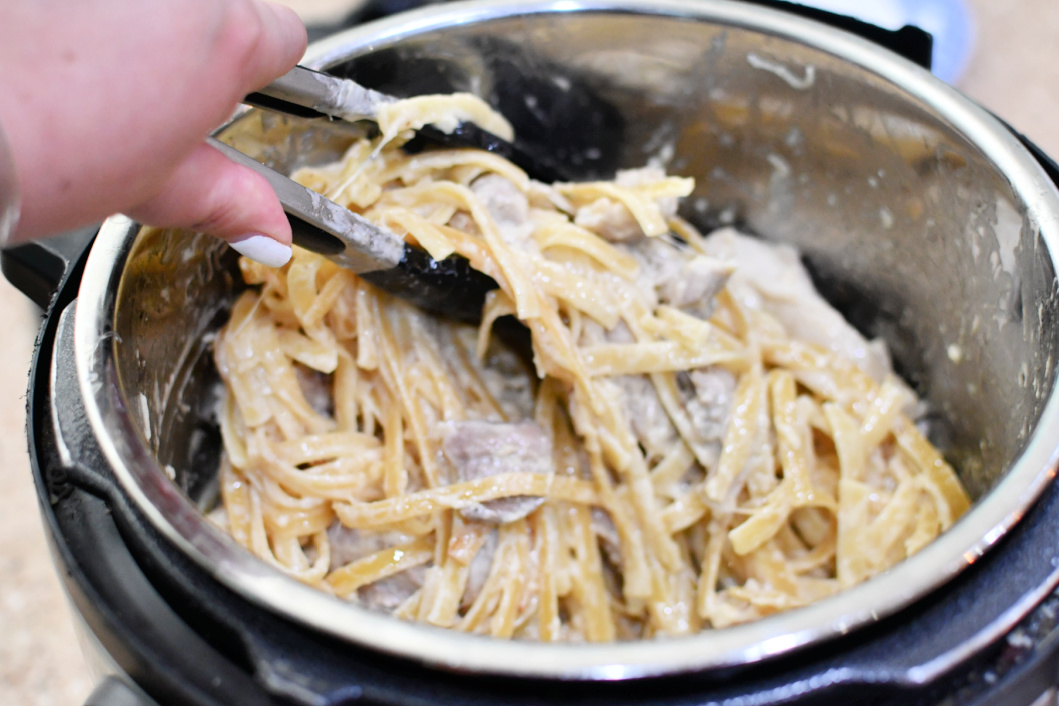 stirring fettuccine alfredo after cooking in Instant Pot