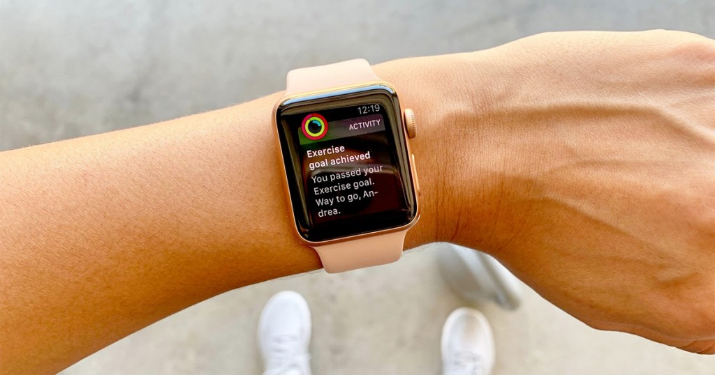 pink apple watch on wrist showing workout goal onlinepleted notification