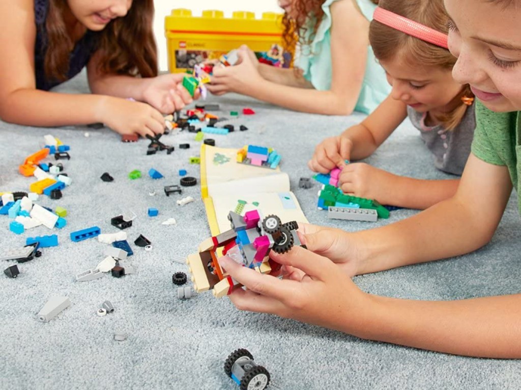 children on carpet playing with building blocks