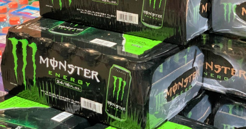 multiple cases of monster energy original green drinks stacked in store