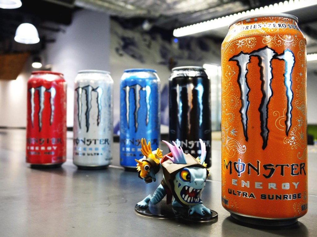 can of Monster Energy Ultra Sunrise with toys next to it and four cans of other monster flavors behind it