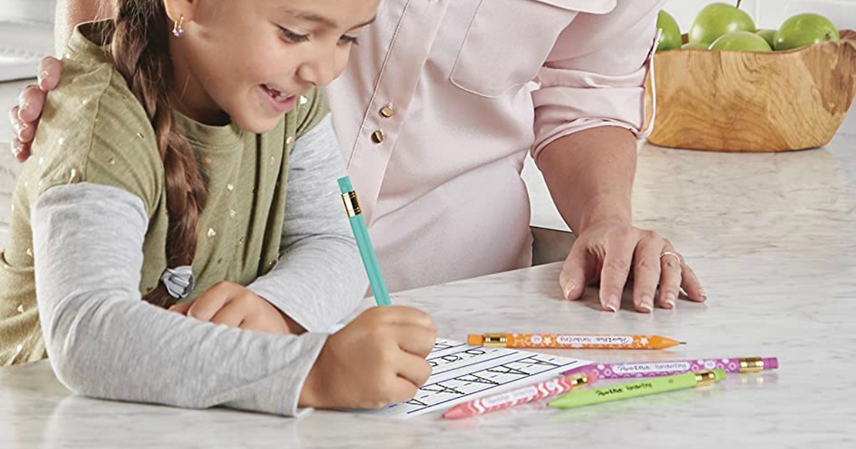 Kid using a large mechanical pencil in a teal color on counter with mom