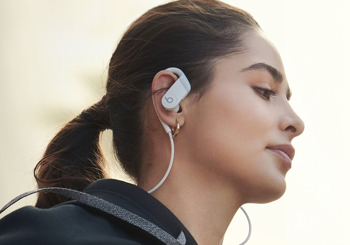 woman wearing a pair of powerbeats earphones that wrap around her ear