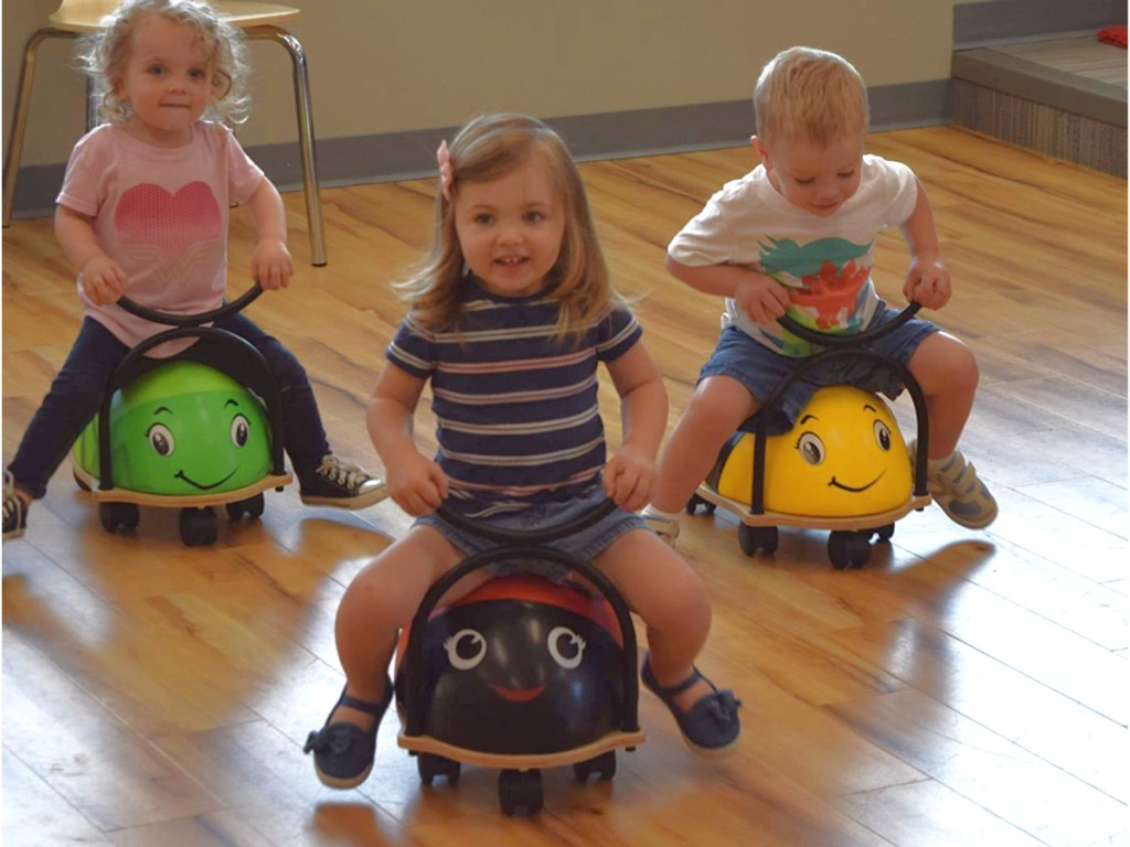 kids sitting on grasshopper, bumble bee and ladybug ride on toys