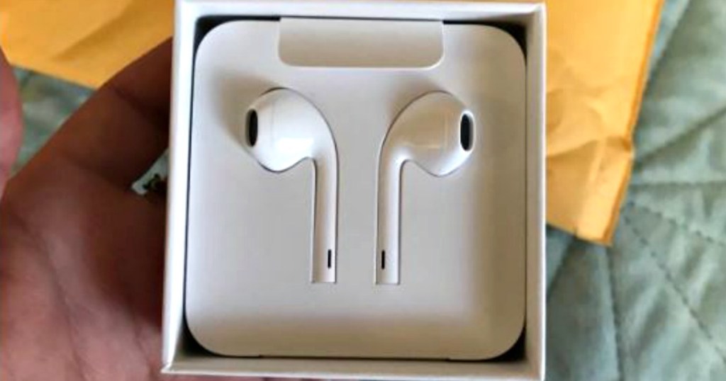 hand holding white earpods