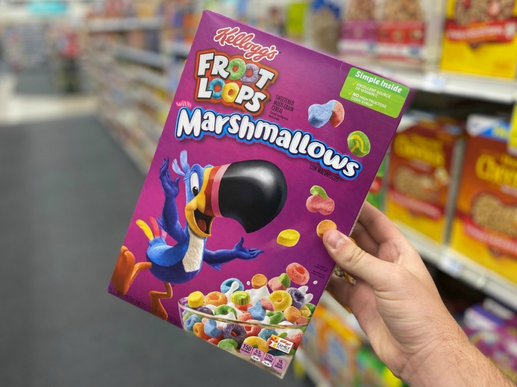 hand holding box of cereal in store aisle