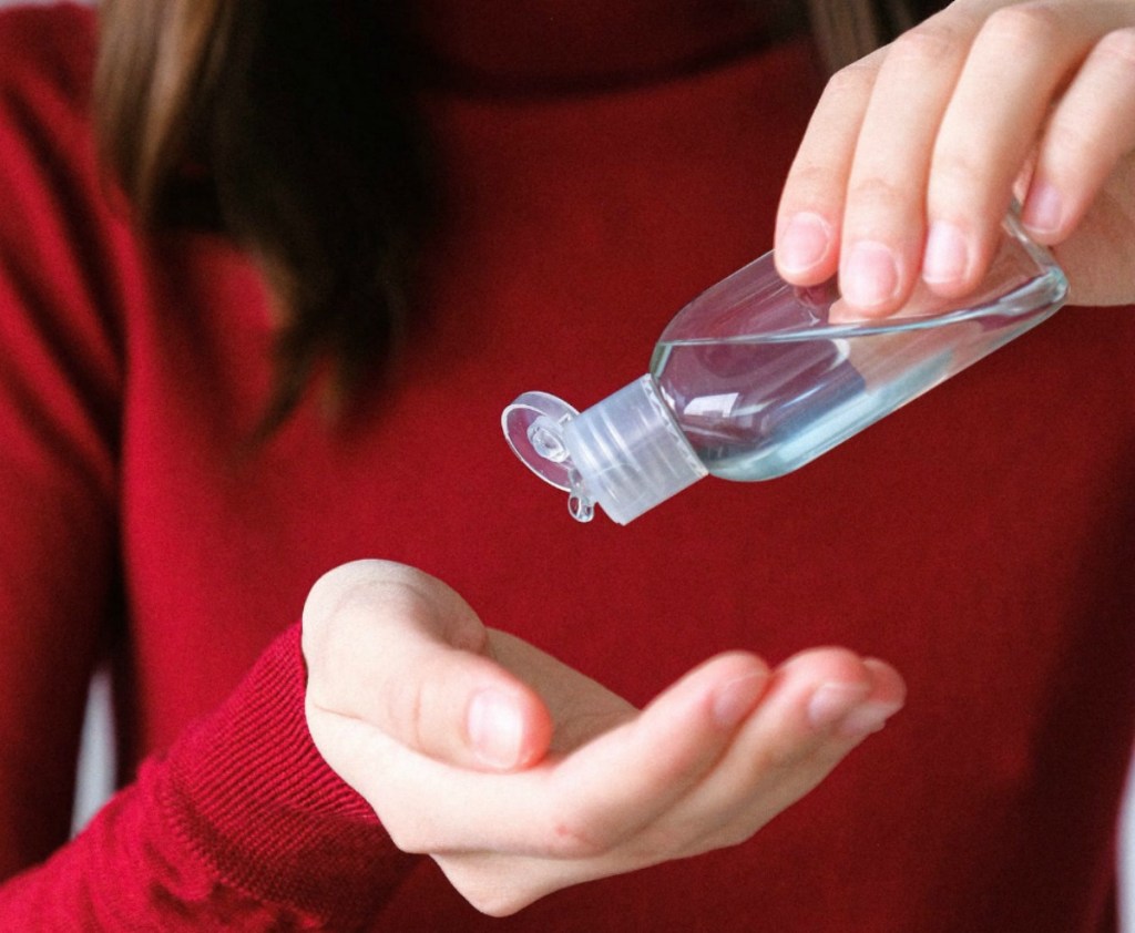 woman putting hand sanitizer on her hand