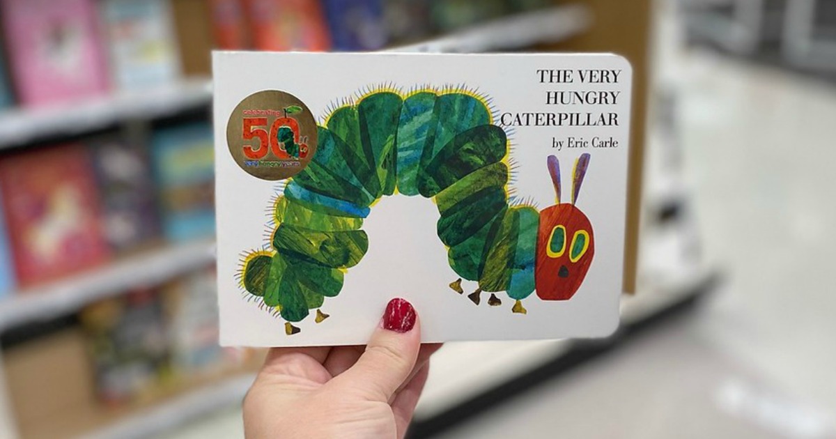 hand holding a book in front of store shelf