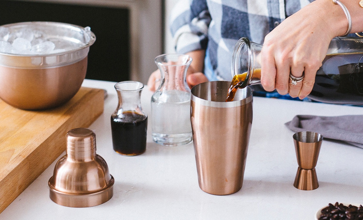 hand pouring iced coffee cocktail