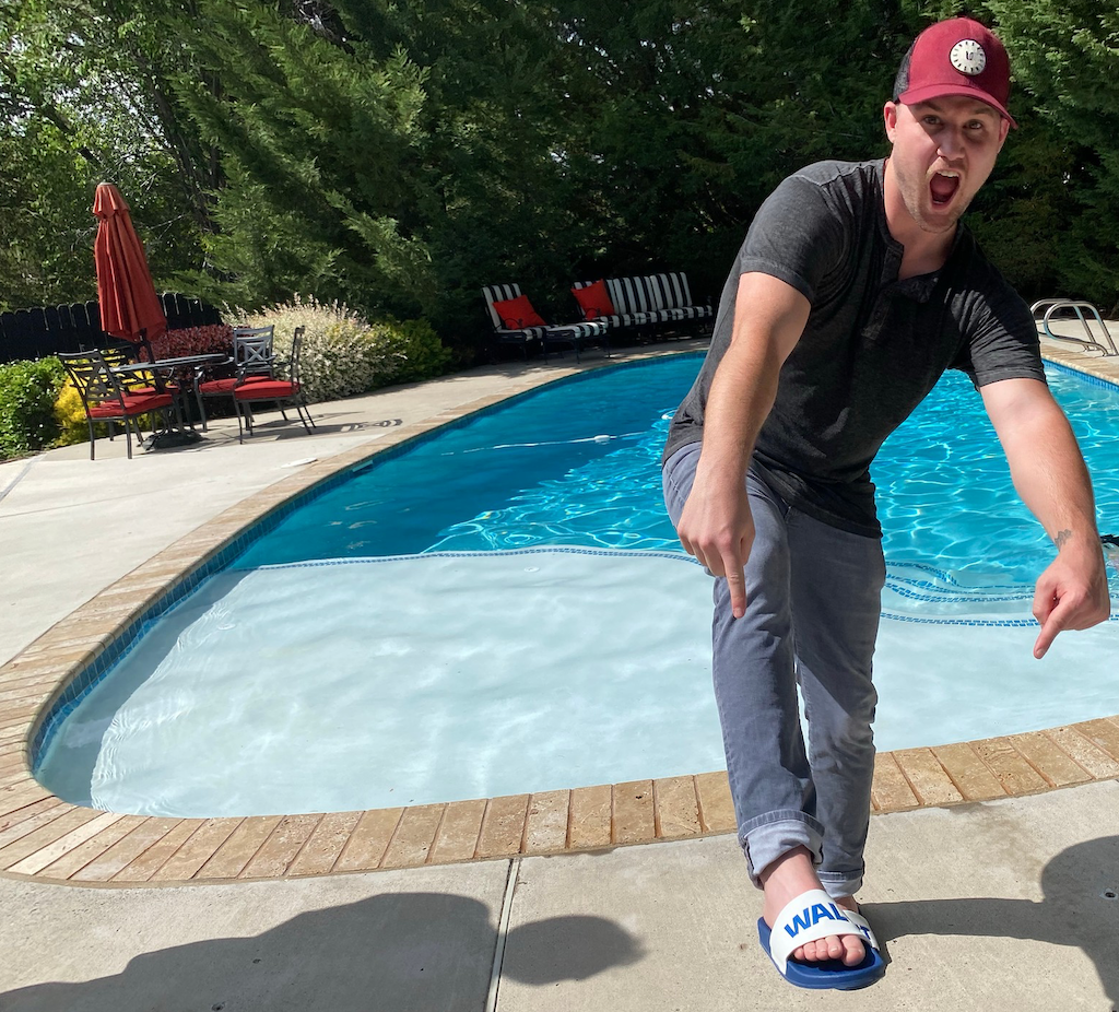 man pointing at Walmart slides by pool 