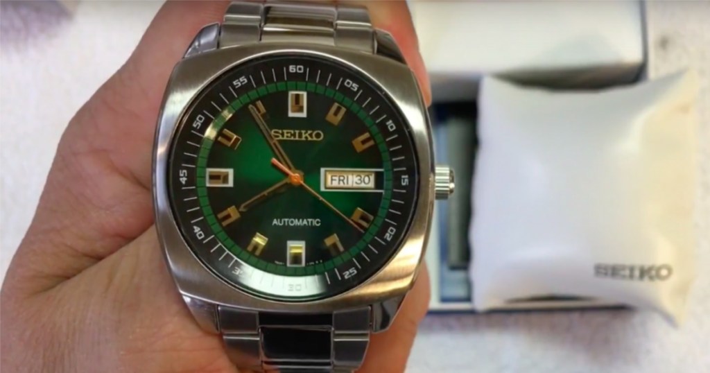 seiko green analog watch in hand