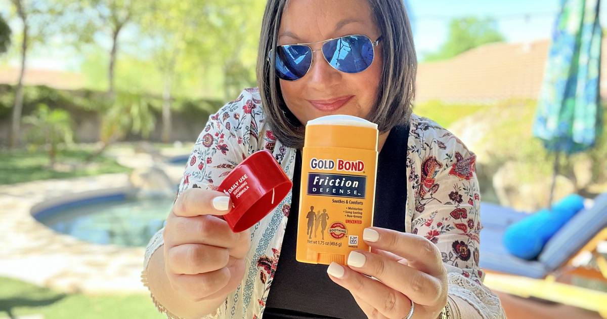 woman holding a stick of gold bond friction defense outside