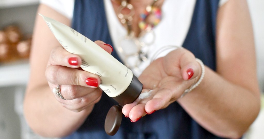 woman putting on ahava hand cream