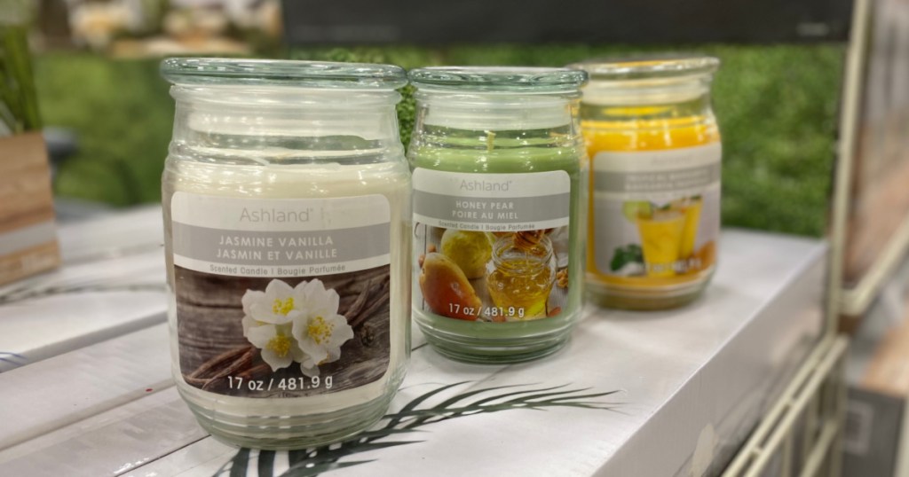 three scented jar candles on counter in store