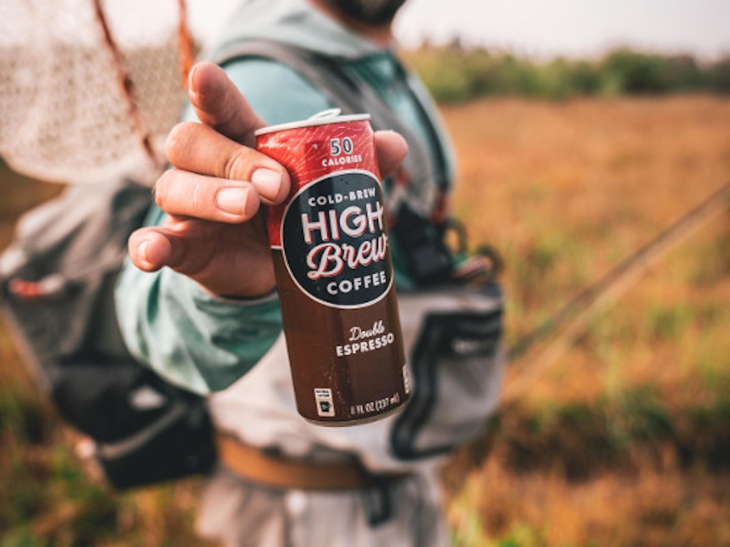 man holding Cold Brew High Brew Double Espresso with fishing gear