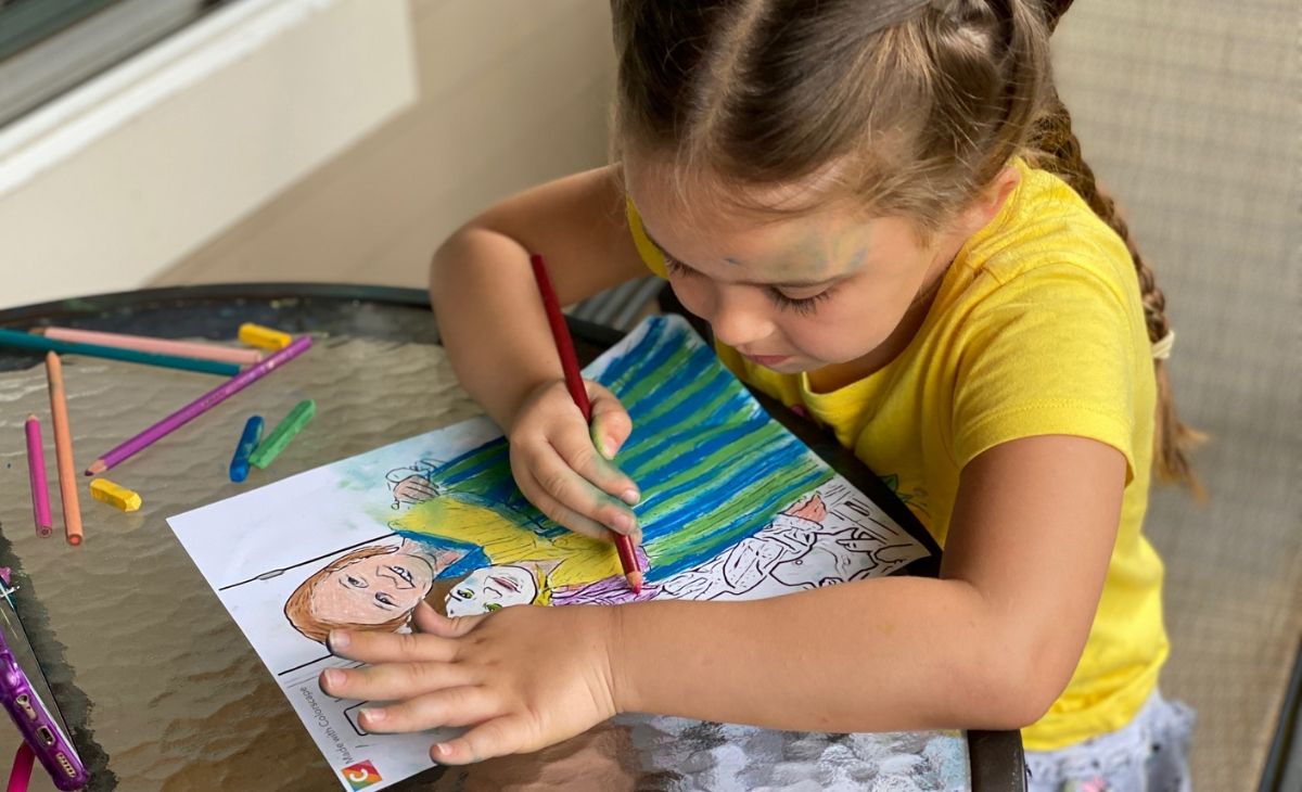 A little girl coloring at a table