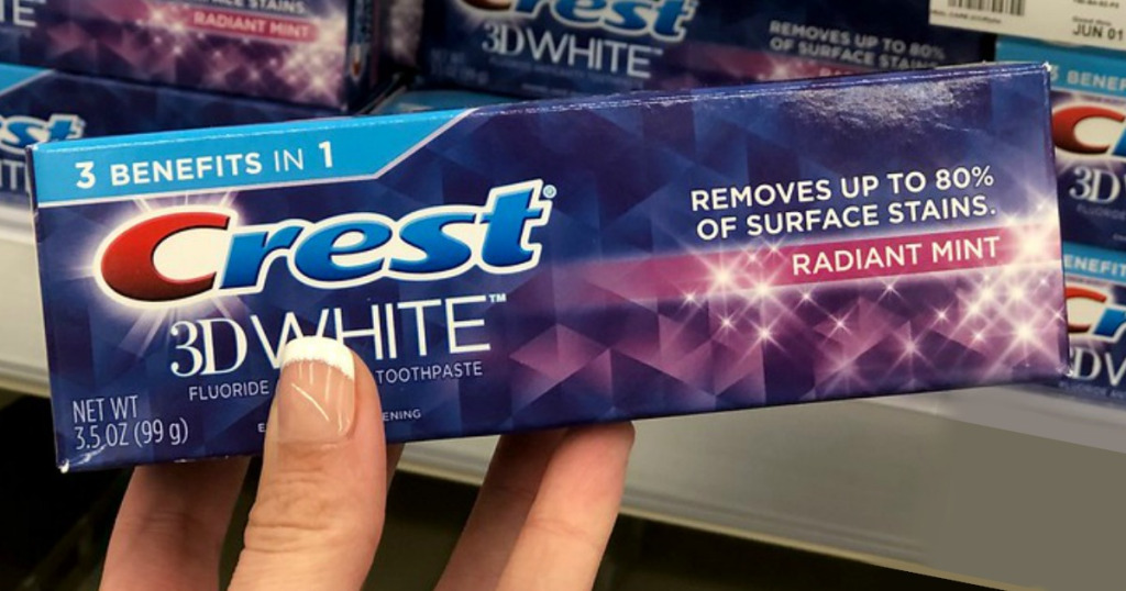 hand holding Crest 3D White toothpaste