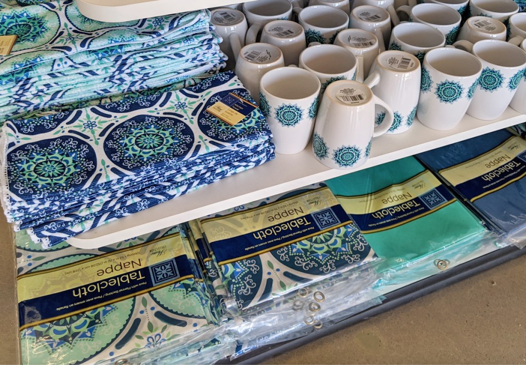 store display with blue and turquoise mediterranean themed coffee mugs and table cloths 