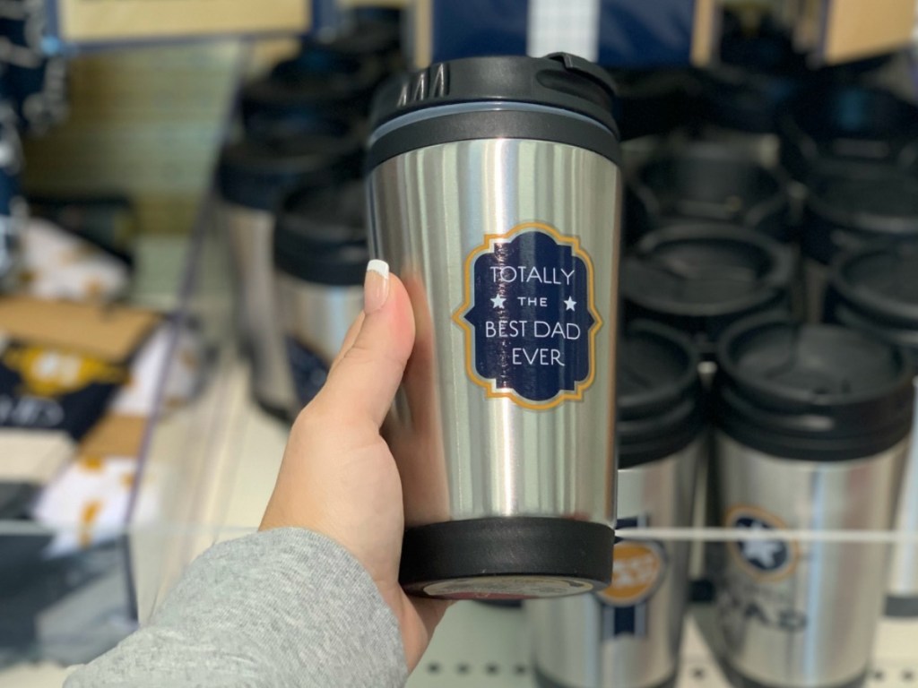 hand holding stainless tumbler by store display