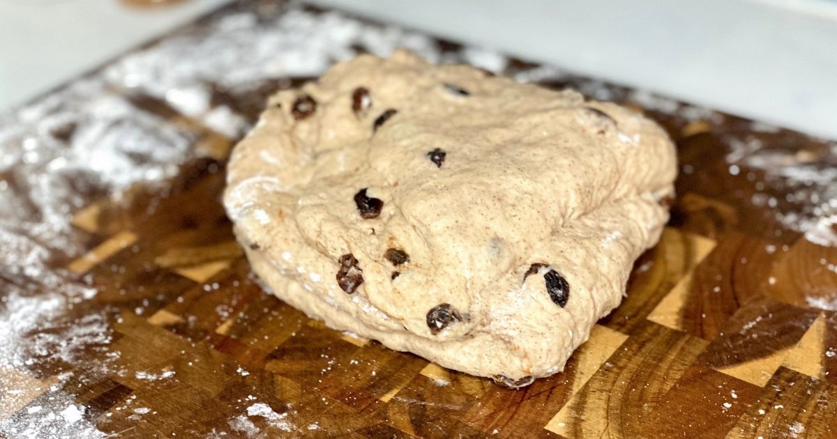 Kneading dough on a cutting board covered in flour