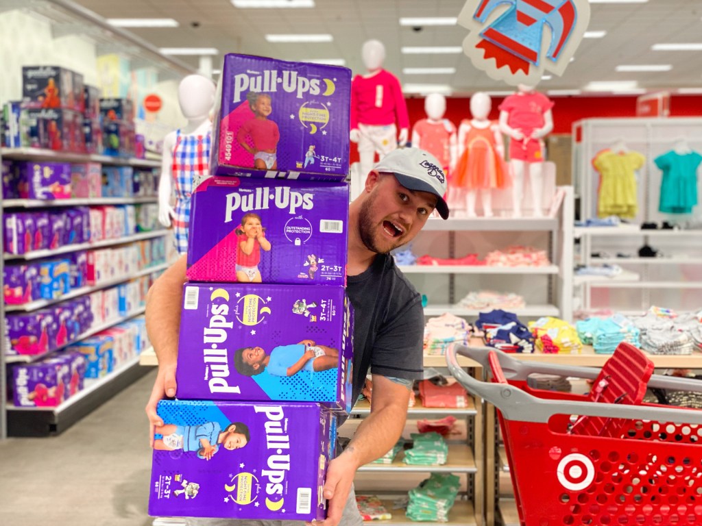 Man Holding Stack of Huggies Pull-Ups