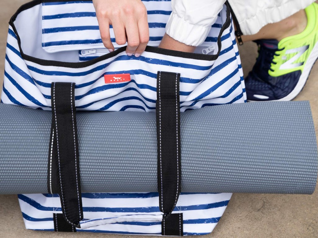 yoga mat in handles of blue and white striped tote bag