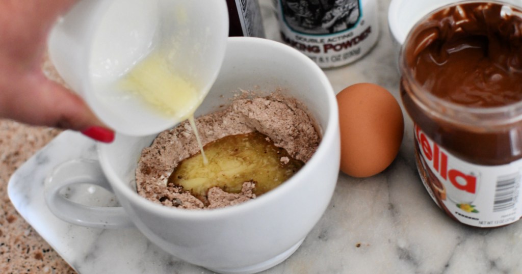 adding butter to mug cake