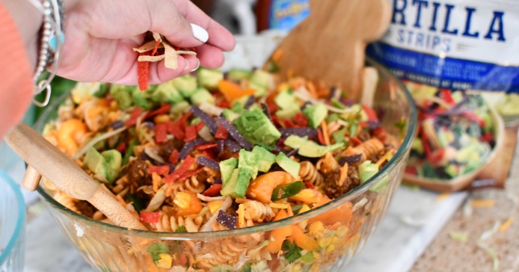 adding tortilla strips to taco salad