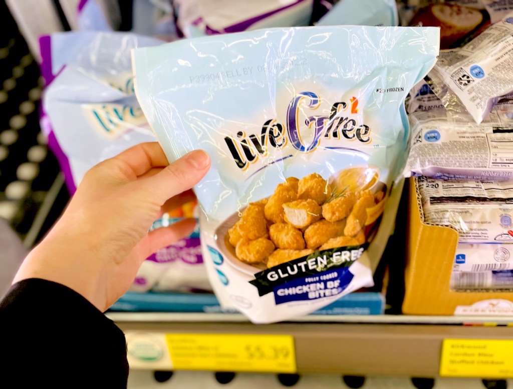 hand holding a bag of gluten free chicken nuggets in store freezer