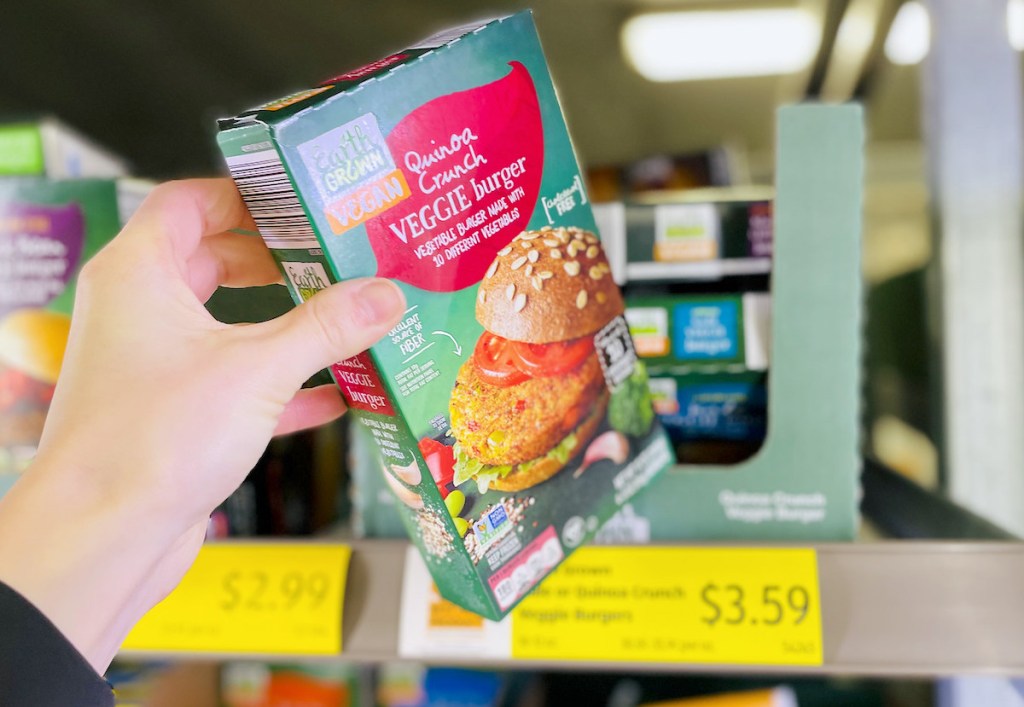 hand holding box of aldi quinoa burgers in freezer section