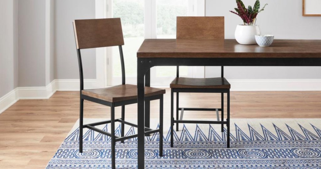 table in kitchen with 2 chairs on a rug