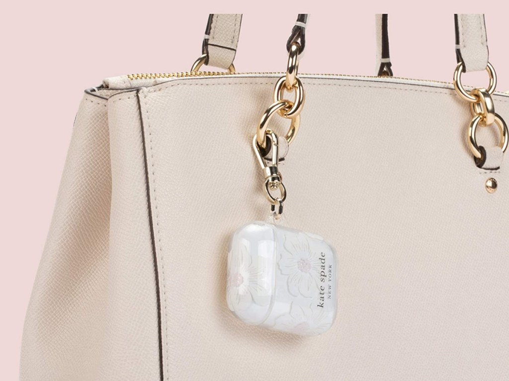 Kate Spade AirPod case hanging off a tan purse