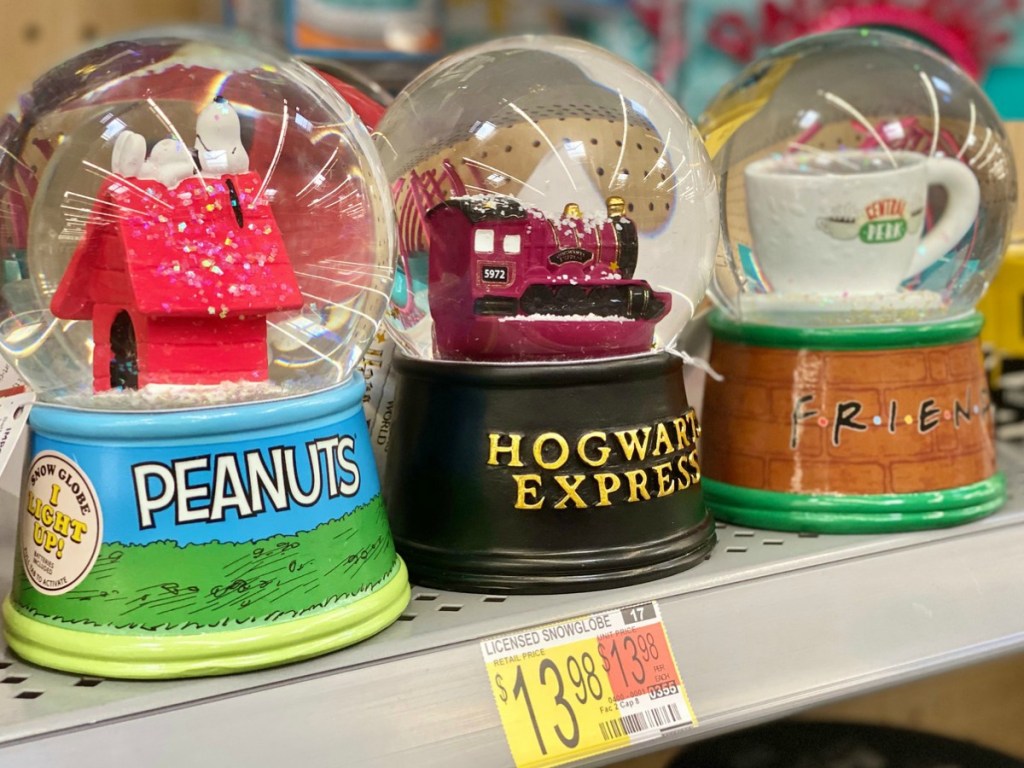 three snowglobes on store shelf near price