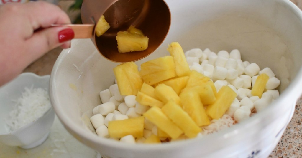 making pineapple fluff salad with pinapples and marshmallows 