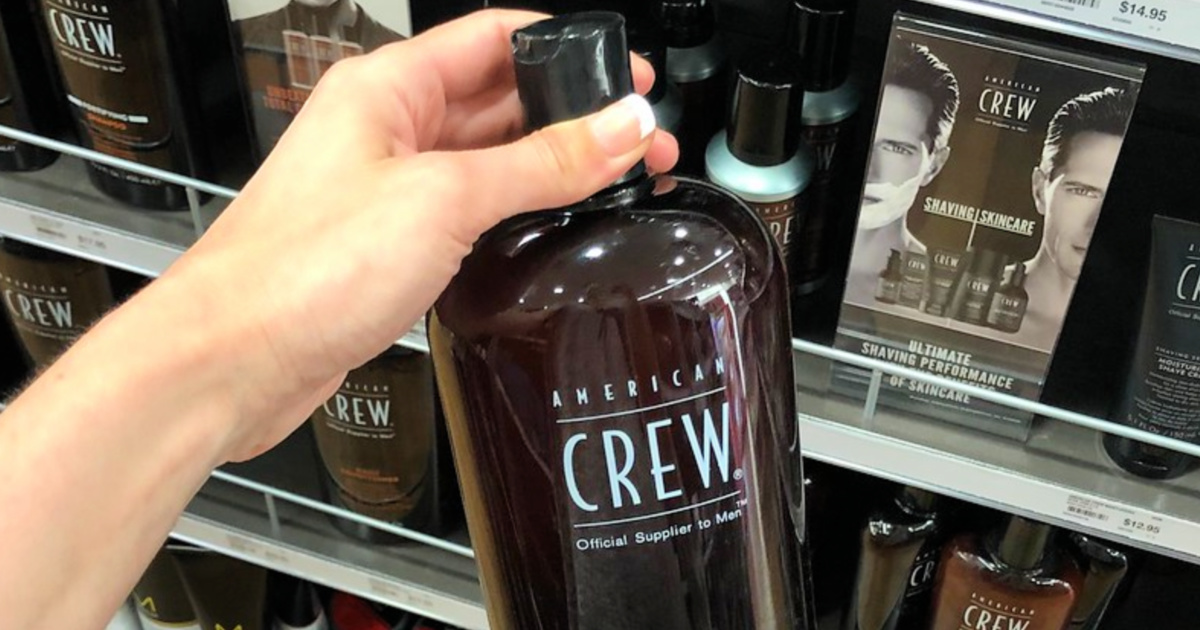 person holding american crew shampoo bottle