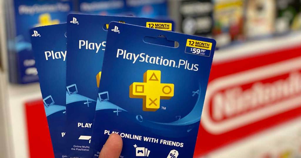 hand holding two playstation plus cards