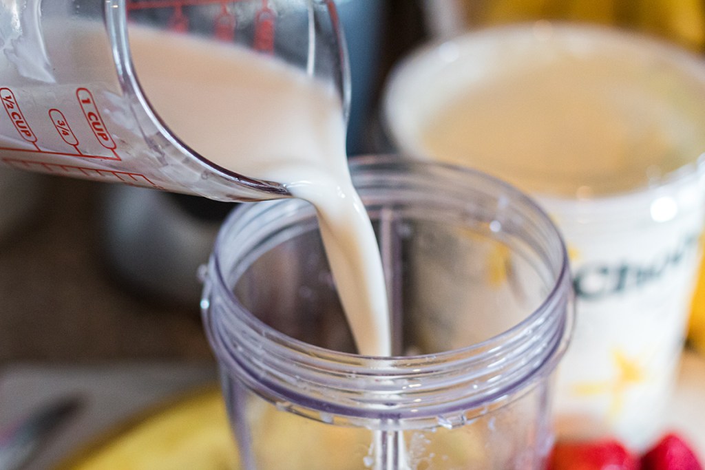 pouring almond milk into nutribullet cup