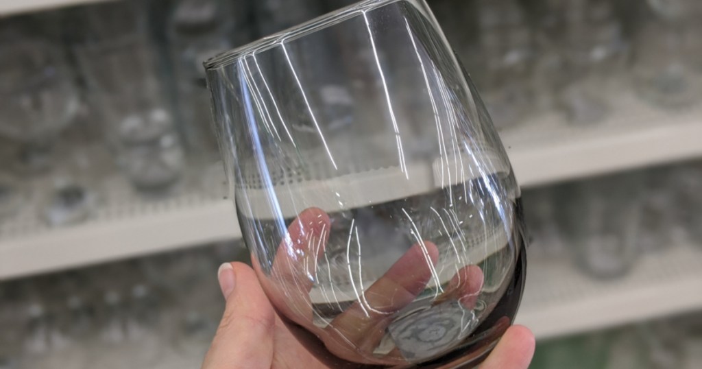 hand holding stemless wine glass