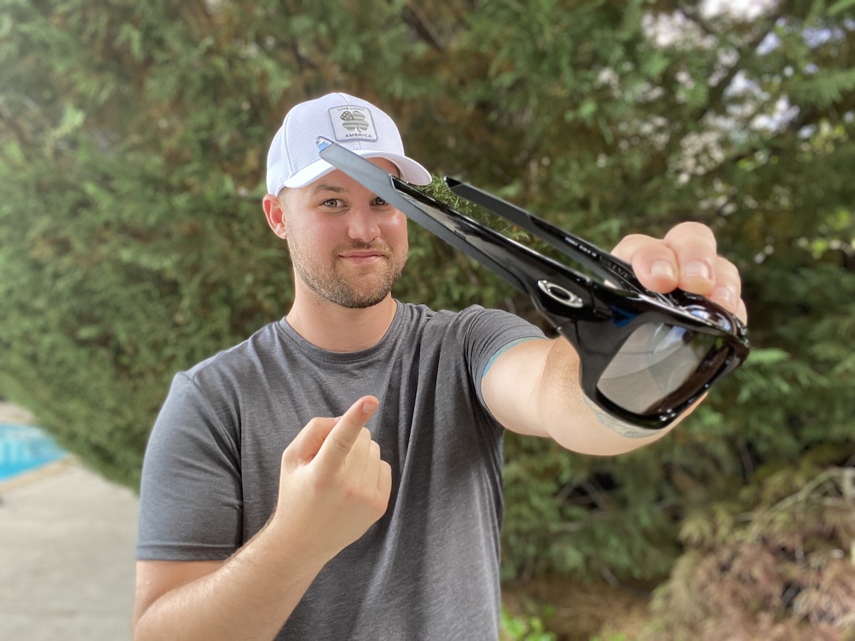 man pointing to the Oakley Men's Valve Sunglasses outside