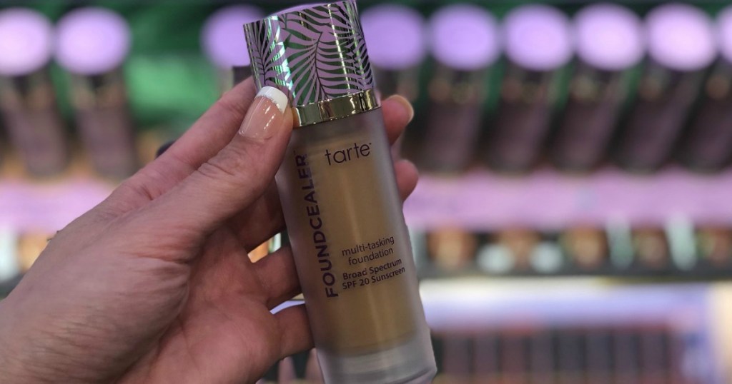 woman holding tarte foundation