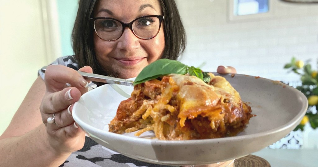 woman holding a plate of million dollar spaghetti